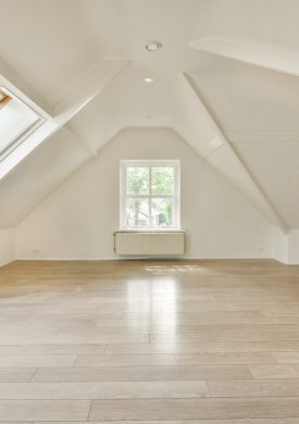 an empty room with wood floors and skylights in the corners on the right side of the room, there is a window