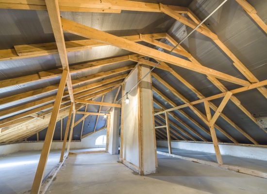 Attic of a building with wooden beams of a roof structure.