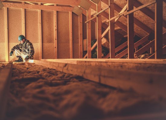 Caucasian Construction Worker in His 40s in the Newly Built Wooden House Attic. Wood Building Theme.