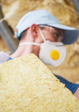 Mineral Rock Wool Insulating Concept Photo. Worker with Piece of Insulating Wool in Hands.